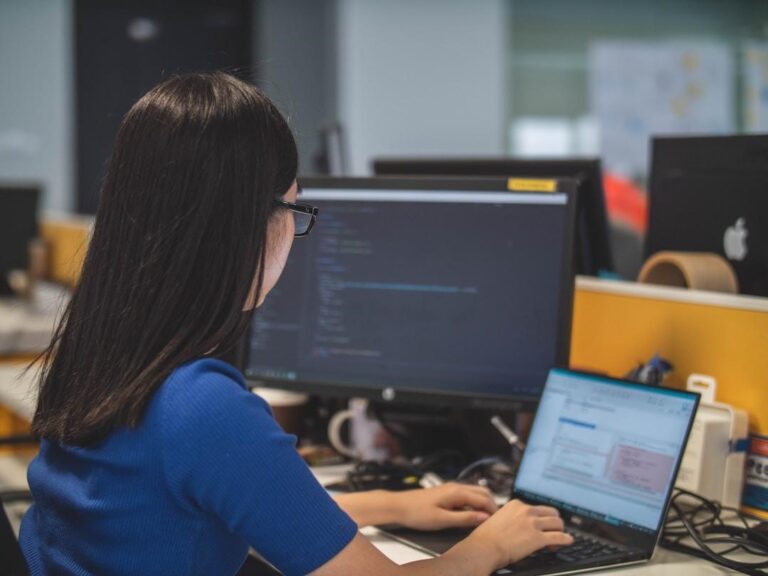 A woman in an office researching project accounting on her computer